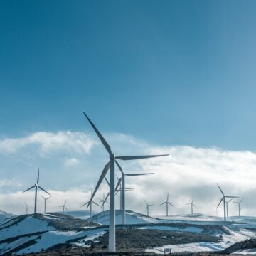 wind turbines on snowy mountain under clear blue sky during daytime