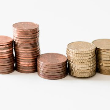 stacked round gold-colored coins on white surface